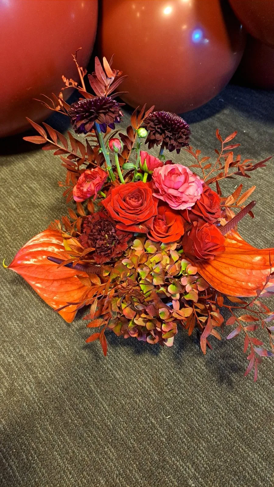 Composition florale automnale avec roses rouges et fond chaleureux