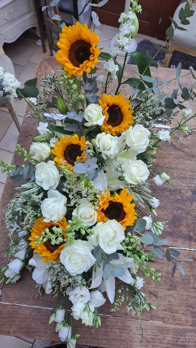 Vue complète d’une composition florale d’hommage blanche et jaune